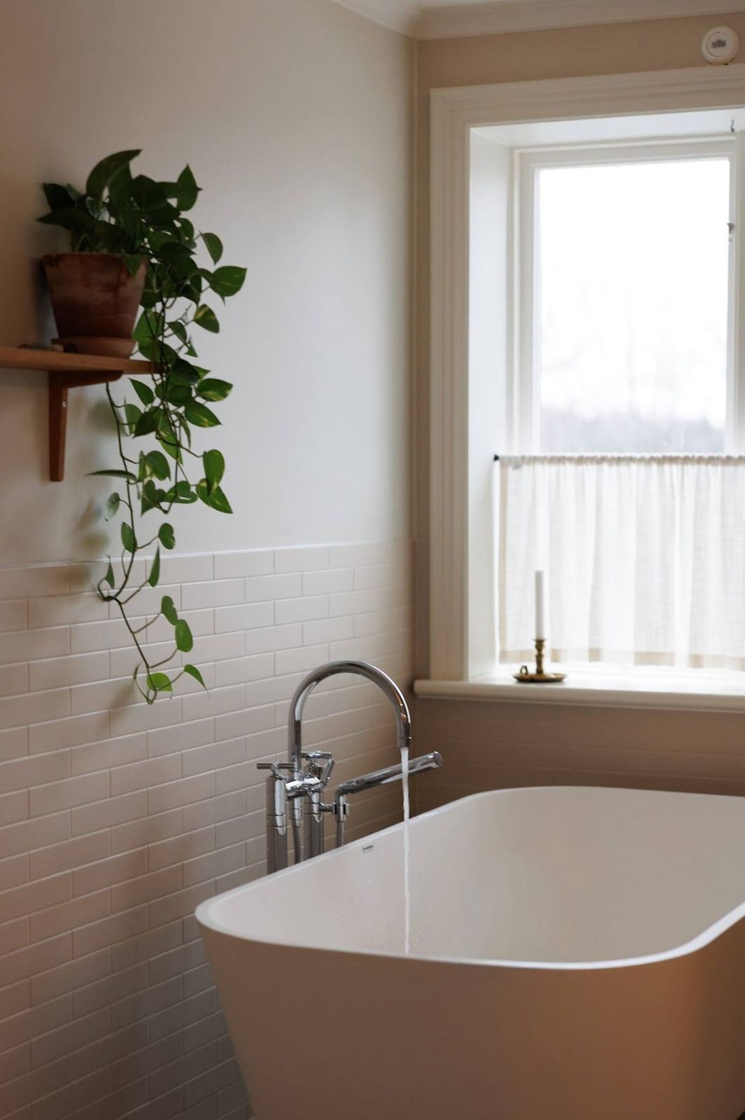 Upstairs bathroom with freestanding tub, subway tile and a trailing plant
