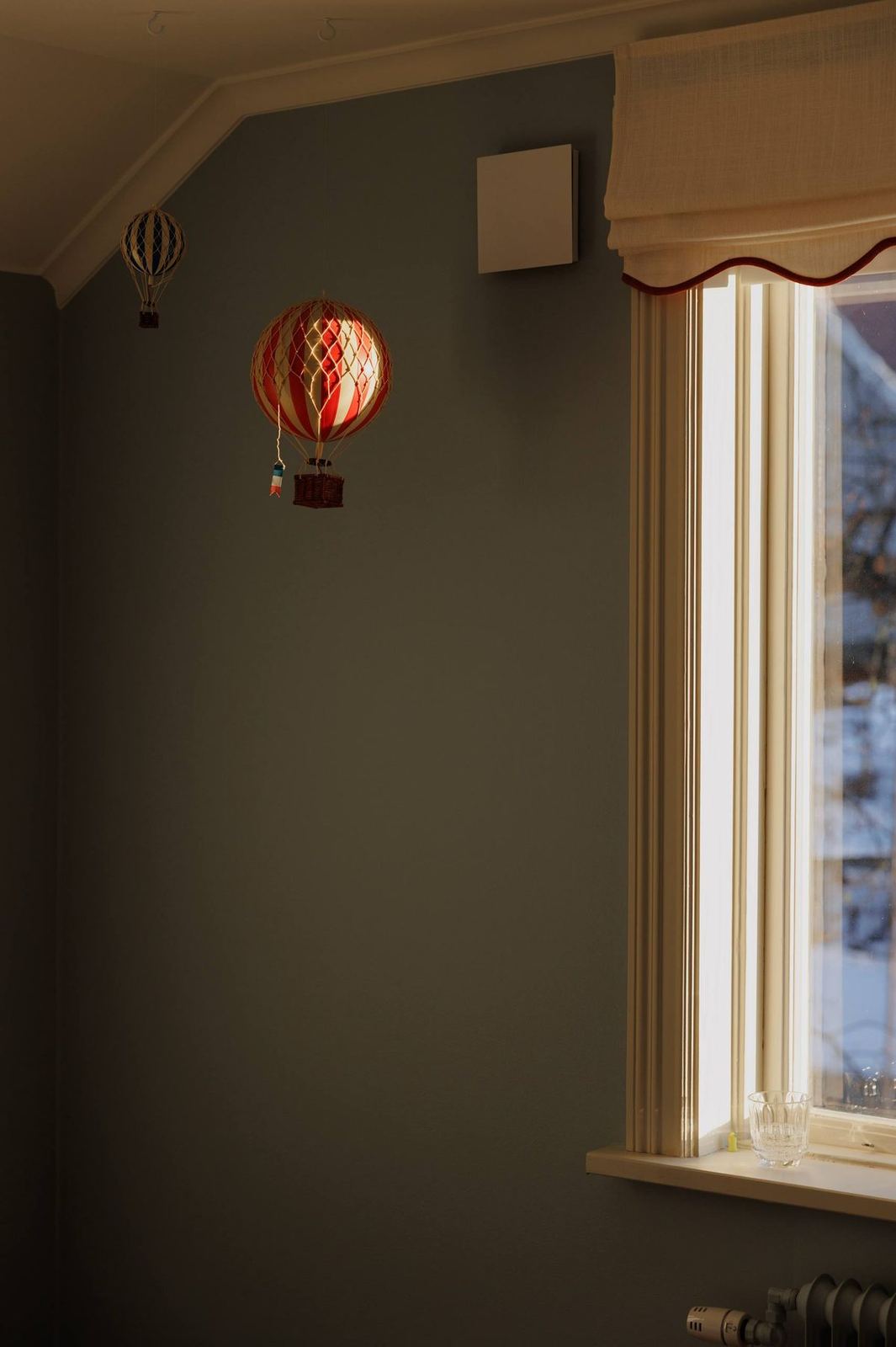 The Blue Room with hot-air-balloon mobiles glowing by the window