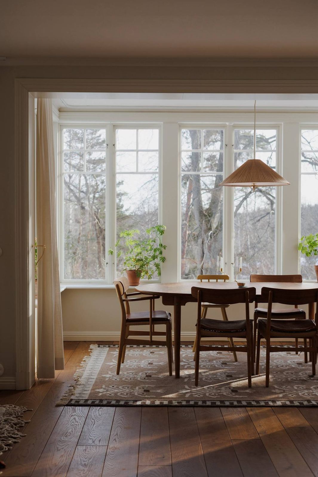 Pleated pendant over mid-century dining chairs