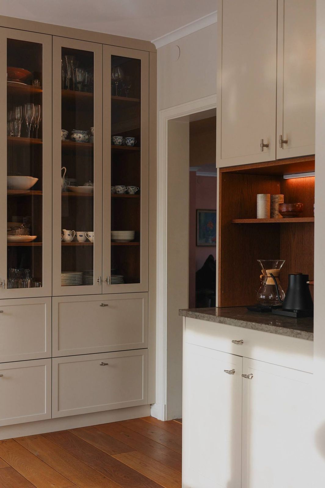 Glass cabinet of blue-and-white china beside the coffee nook