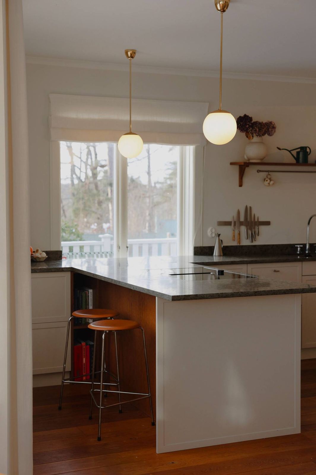 Kitchen island with stone top and brass globe pendants