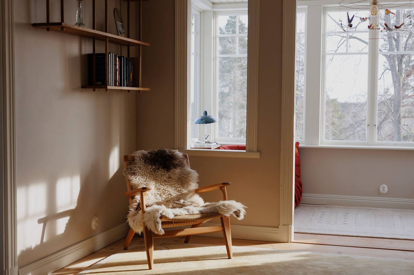 Upstairs sitting room with sheepskin-draped chair in low winter light