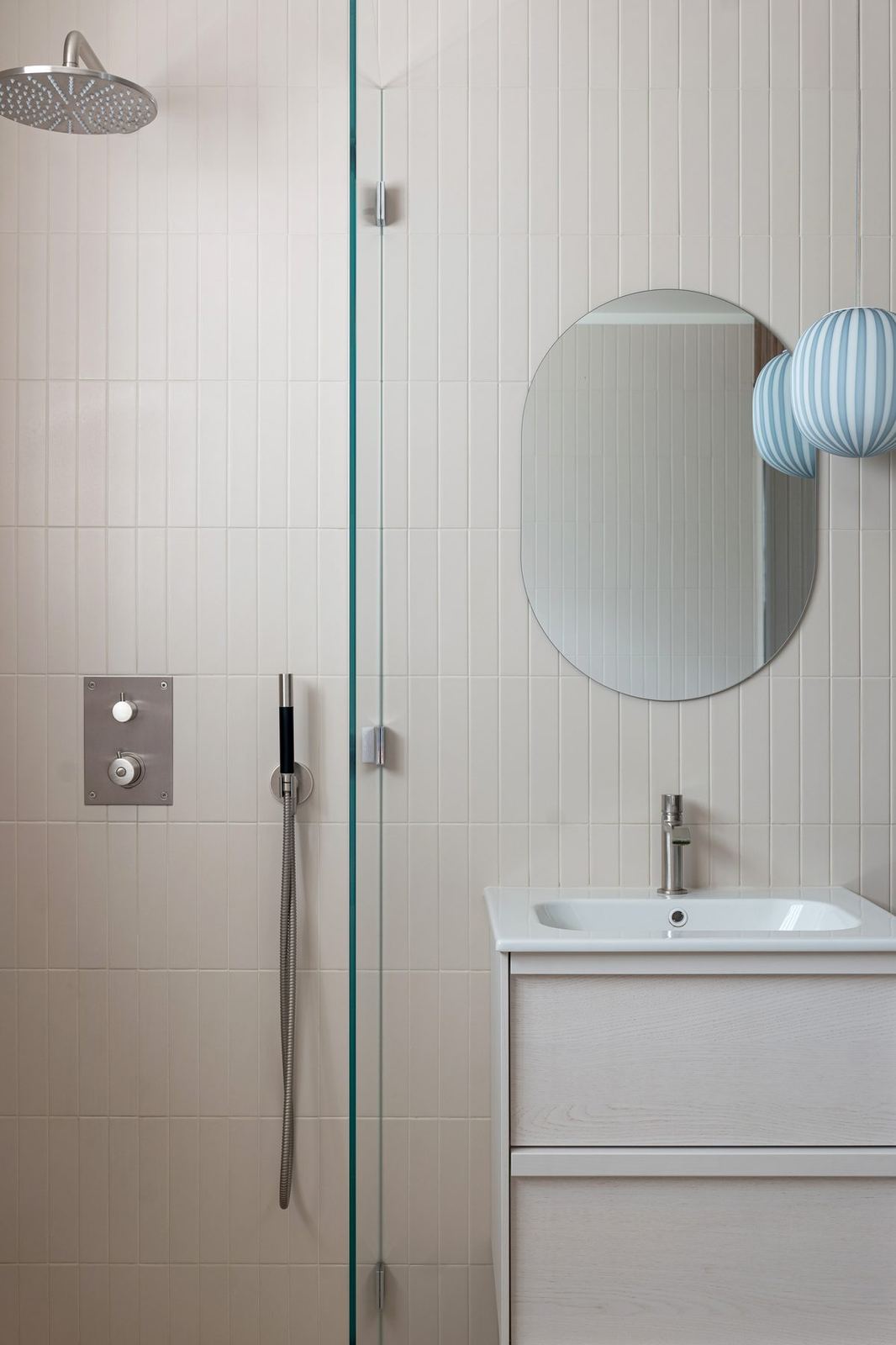 Rain shower, oval mirror and striped pendant in the spa