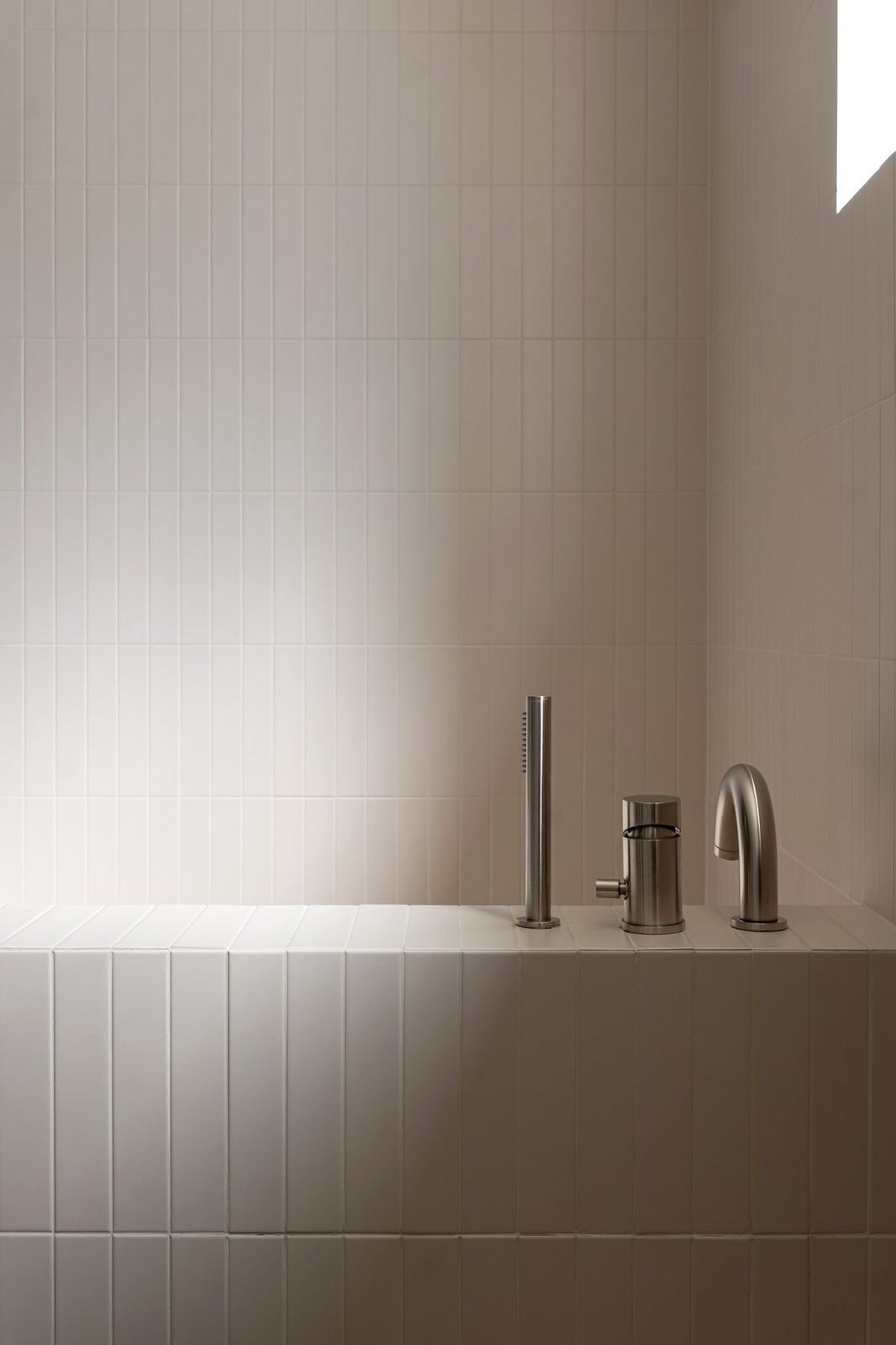 Deep tiled spa tub with brushed-steel tap